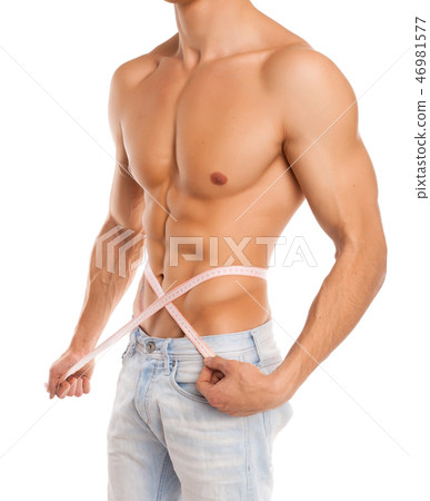 Man measuring his waist in studio 46981577