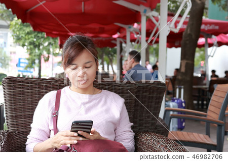 Woman using smart phone in cafe Woman using smart phone in cafe 46982706