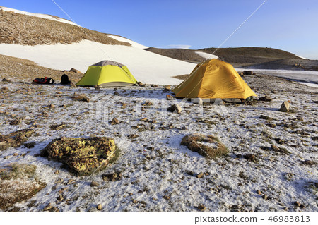 Tent of tourists are located at foot of mountain. Tent of tourists are located at foot of mountain. 46983813