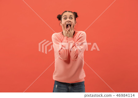 Beautiful woman looking suprised isolated on coral Beautiful woman looking suprised isolated on coral 46984114