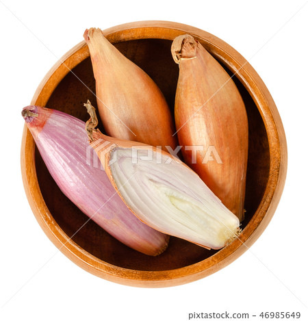 Long shallots, whole and sliced, in wooden bowl Long shallots, whole and sliced, in wooden bowl 46985649