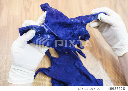 craftsman checks the felted glove after fulling 46987328