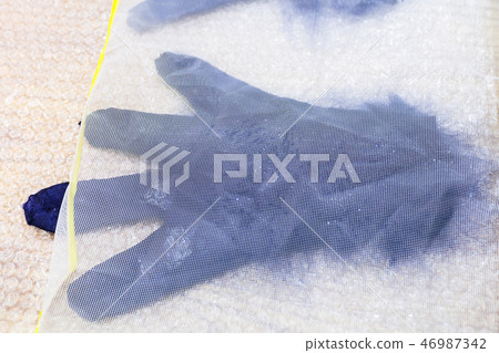 wet glove with new fibers under plastic mesh 46987342