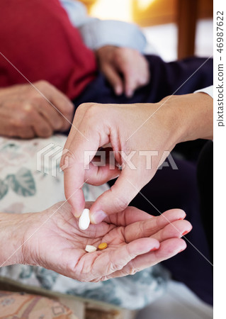 doctor giving some pills to a senior woman doctor giving some pills to a senior woman 46987622