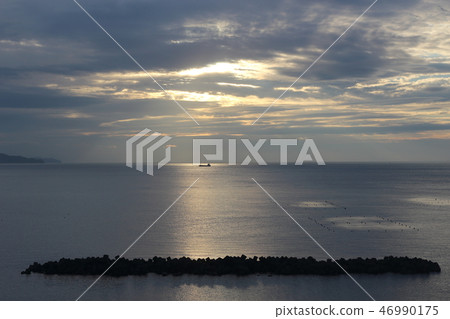 A ship sailing in the morning sun 46990175