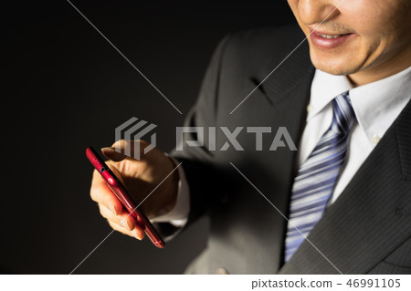 看著智能手機微笑的無能商人 看著智能手機微笑的無能商人 46991105