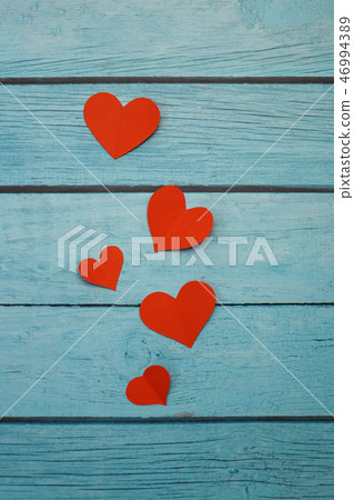 Red paper hearts on a blue wooden background Red paper hearts on a blue wooden background 46994389