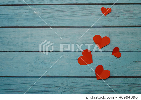 Red paper hearts on a blue wooden background 46994390