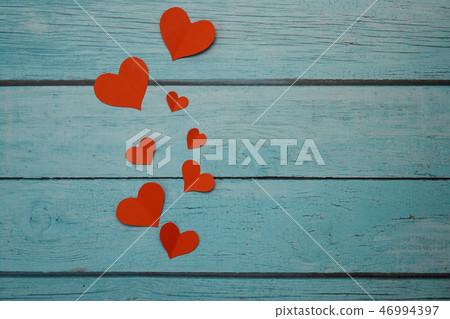 Red paper hearts on a blue wooden background 46994397