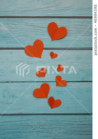 Red paper hearts on a blue wooden background 46994398