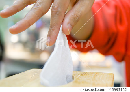 woman hand pick napkin paper from tissue box 46995132