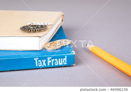 tax fraud concept. blue book on a gray office table tax fraud concept. blue book on a gray office table 46996236