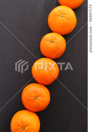 Mikan oranges black back lined up in a straight line Mikan oranges black back lined up in a straight line 46997573