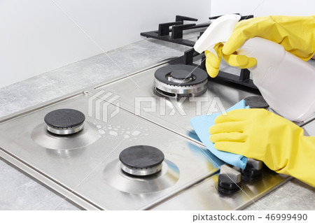 Cleaning a gas stove with kitchen utensils, household concepts, or hygiene and cleaning. 46999490