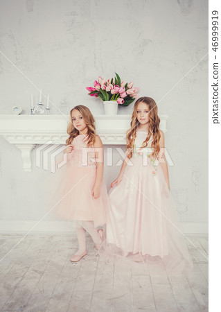 Two cute little girls standing in dress Two cute little girls standing in dress 46999919