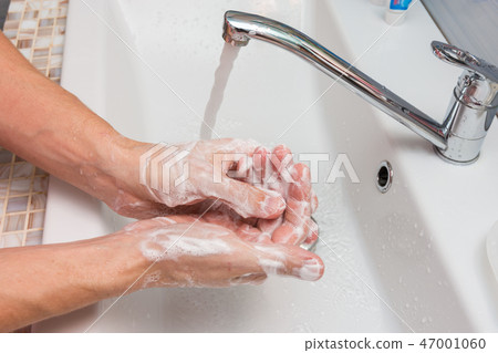 Washing hands with soap in the sink Washing hands with soap in the sink 47001060