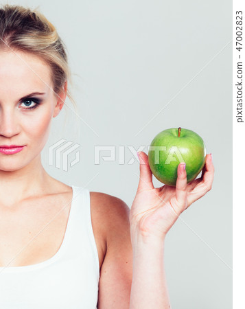 Fit woman holding apple fruit, dieting concept 47002823