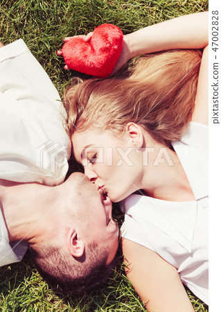 Man and woman lying on grass having date 47002828