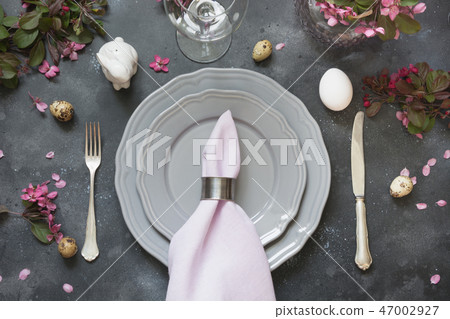 Easter table setting with pink flowers on dark. Easter table setting with pink flowers on dark. 47002927