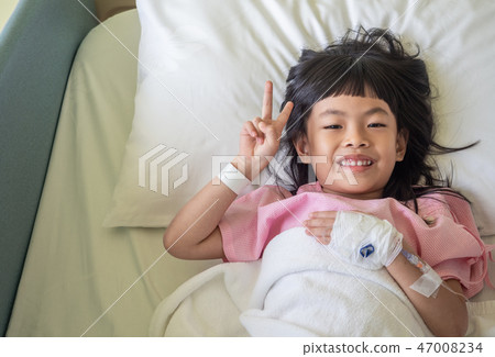 Asian child show two finger on bed Asian child show two finger on bed 47008234