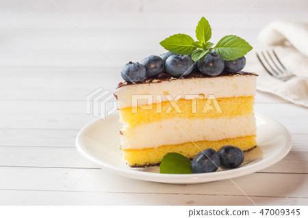 Cake of a souffle with glaze and fresh blueberries Cake of a souffle with glaze and fresh blueberries 47009345