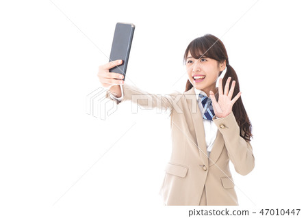 Students in uniforms using a smartphone Students in uniforms using a smartphone 47010447