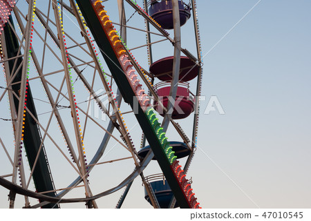 amusement park carousel big wheel on blue sky 47010545
