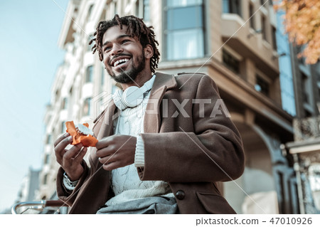 Delighted brunette male enjoying walk in city center 47010926