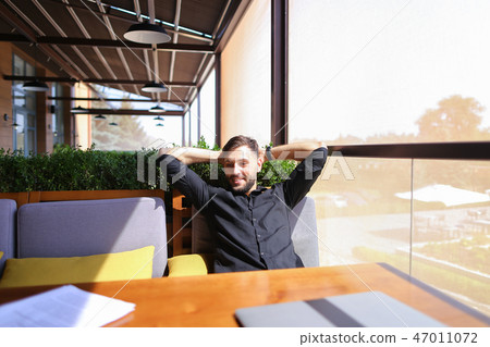 Translator sorting papers and closing laptop lid. Translator sorting papers and closing laptop lid. 47011072
