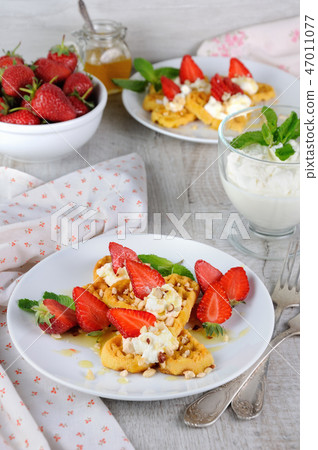 Belgian waffles   whipped cream and strawberries 47011077