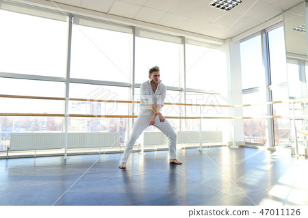 Young blonde dancer enjoys winning in white suit and makes warm Young blonde dancer enjoys winning in white suit and makes warm 47011126