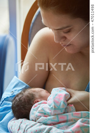 Mom breastfeeding newborn baby Mom breastfeeding newborn baby 47011498
