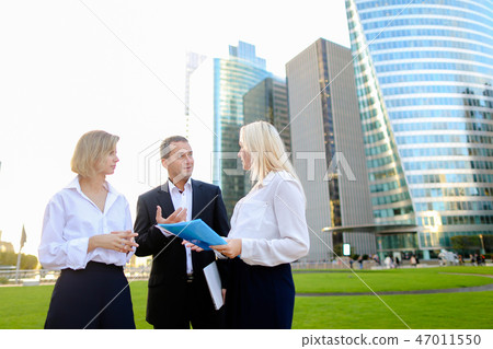 Businesswomen speaking with male boss outside. Businesswomen speaking with male boss outside. 47011550