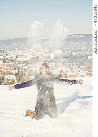 Crazy woman throws white snow, yellow filter Crazy woman throws white snow, yellow filter 47012848