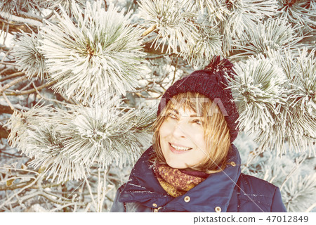 Young woman under the snowy coniferous tree Young woman under the snowy coniferous tree 47012849