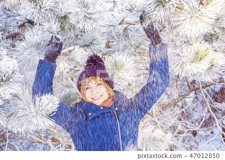 Young smiling woman under snowy coniferous tree Young smiling woman under snowy coniferous tree 47012850