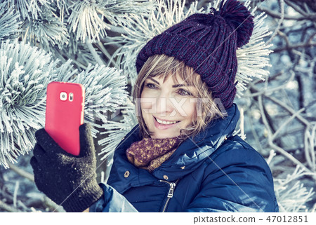 Young woman take selfie photo in winter outdoors Young woman take selfie photo in winter outdoors 47012851