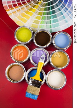 Can with paint and paintbrush, red background Can with paint and paintbrush, red background 47013752