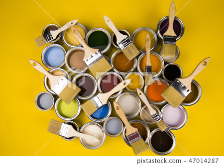 Tin cans with paint and brushes, yellow background Tin cans with paint and brushes, yellow background 47014287