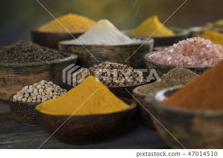 Variety of spices and herbs on kitchen table 47014510