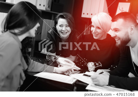 Smiling employees talking in workplace 47015168