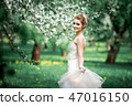 Portrait of young woman in the flowered garden in the spring time. 47016150