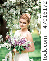 Portrait of young woman in the flowered garden in the spring time. 47016172