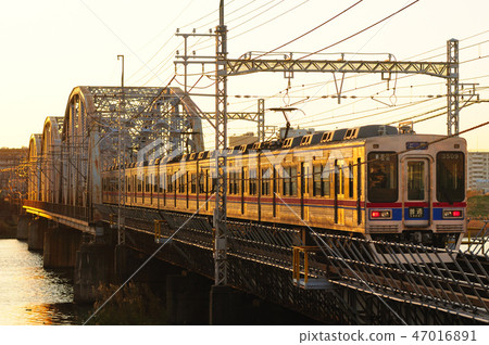 京成火車穿越鐵路橋在夕陽下 京成火車穿越鐵路橋在夕陽下 47016891