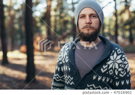 a young man with a beard walks in a pine forest. a young man with a beard walks in a pine forest. 47016902