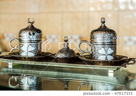 Covered coffee cup with metal decoration 47017355