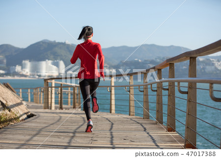 fitness woman runner running on seaside boardwalk 47017388