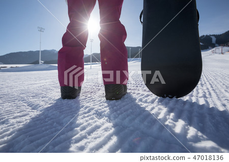 snowboarder with snowboard stand on ski piste snowboarder with snowboard stand on ski piste 47018136
