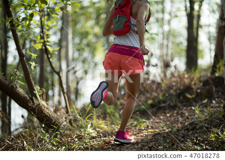 Sportswoman cross country trail running in forest Sportswoman cross country trail running in forest 47018278