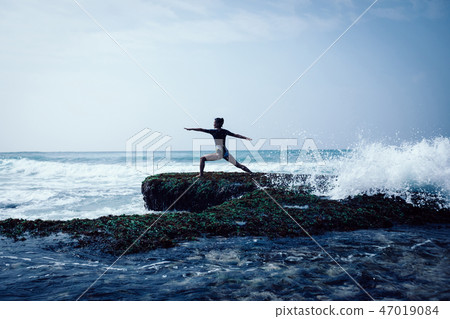 woman practice yoga at the seaside cliff edge woman practice yoga at the seaside cliff edge 47019084